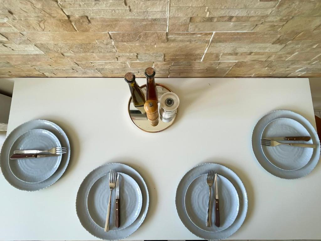 a table with plates and utensils on it at Sunny Beach House in Korinthos