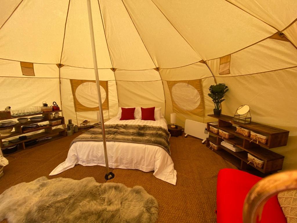 ein Schlafzimmer mit einem Bett in einem Zelt in der Unterkunft Glamping Red Wharf Bay in Pentraeth