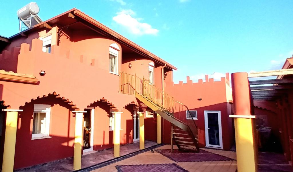 a building with a staircase on the side of it at Aladin Comfort Country Rooms in Campinho