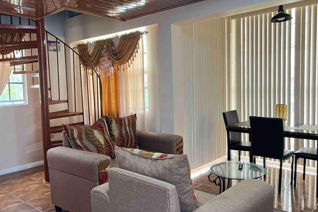 - un salon avec un canapé et une table dans l'établissement Odyssey Suites Loft Apartment, à Georgetown