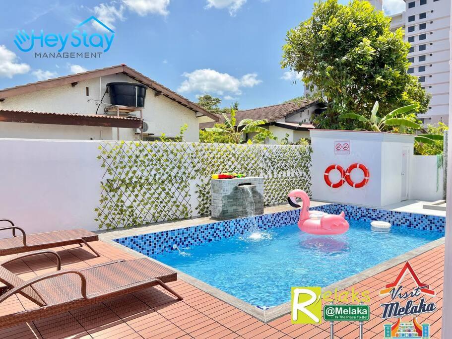 a swimming pool with a pink swan in a backyard at Klebang Villa 17Pax PrivateSwimmingPool TownArea By Heystay Management in Melaka