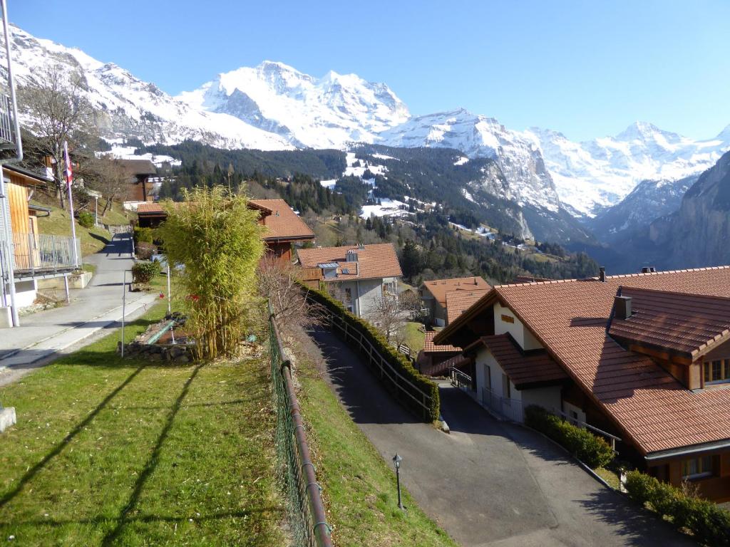 a village with snow covered mountains in the background at Chalet Gerbera in Wengen