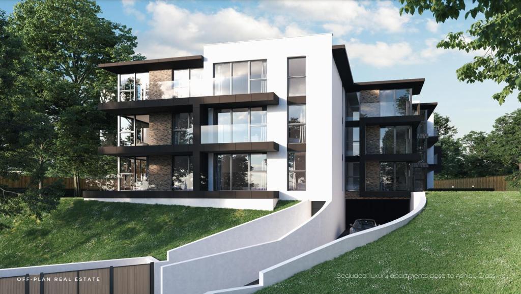 a rendering of a modern apartment building with grass at Aurora Ashley Cross in Poole