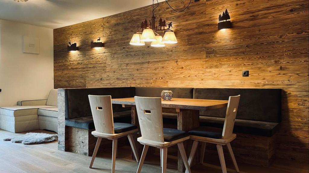 uma sala de jantar com uma mesa de madeira e cadeiras em Appartments Raffele em San Candido