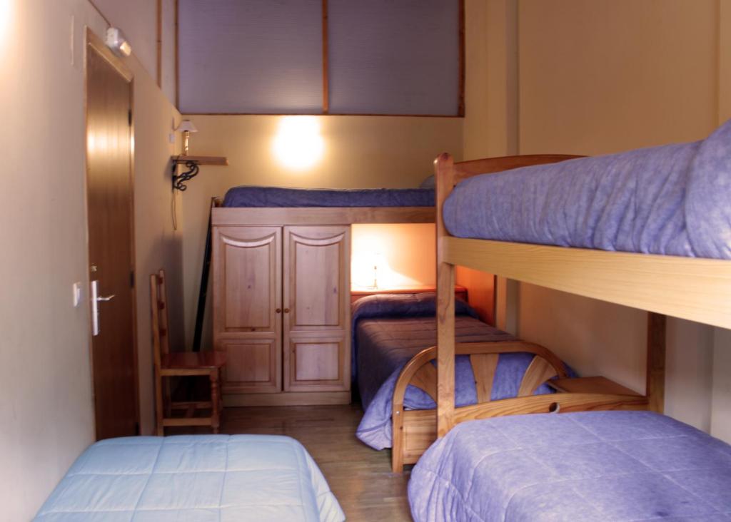 a small room with two bunk beds in it at Albergue Turístico Via de la Plata in Baños de Montemayor