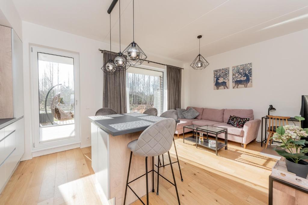 a kitchen and living room with a table and chairs at Mesiheina Apartment in Pärnu