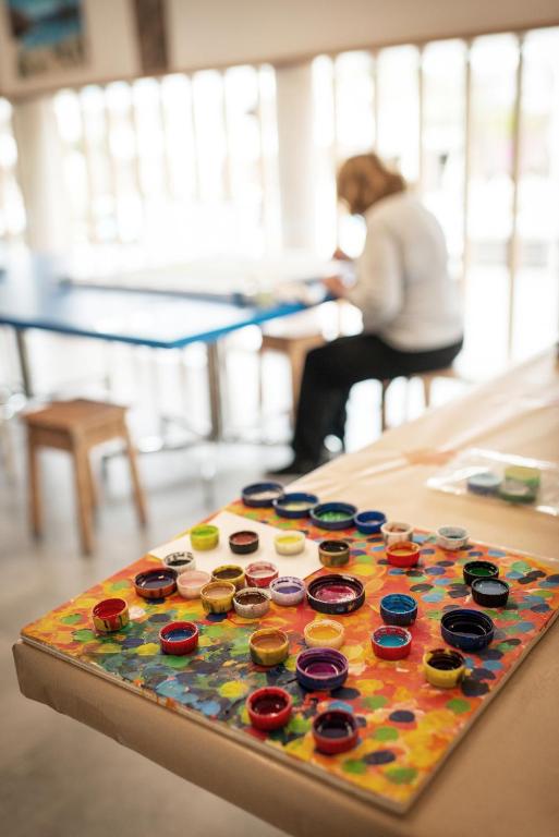 a woman sitting at a table with a colorful button board at Sotavento Beach Club in Costa Calma