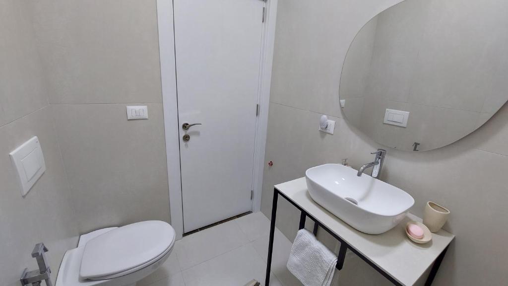 un bagno con un water, un lavandino e uno specchio di Amelja's Apartment a Shkodër