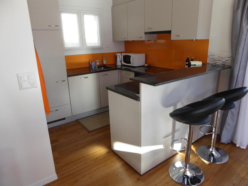 a kitchen with white cabinets and a black counter top at Chalet Gerbera in Wengen