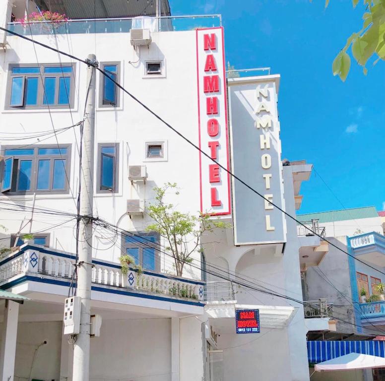 een wit gebouw met een bord voor een hotel bij Khach san Nam Hotel in Bản Co