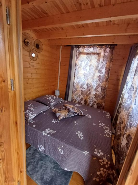 Bett in der Ecke eines Zimmers in einer Hütte in der Unterkunft Le Chalet d'EVOA in L’Étang-Salé