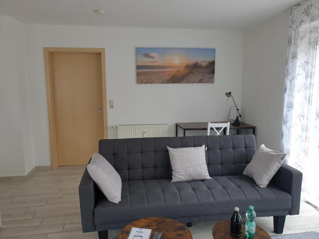 Ferienwohnung Varli في توتلِنغين: غرفة معيشة مع أريكة زرقاء وطاولة