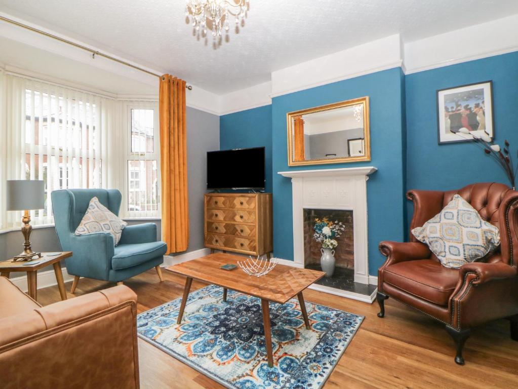 a living room with blue walls and a fireplace at Cornerside in Sidmouth