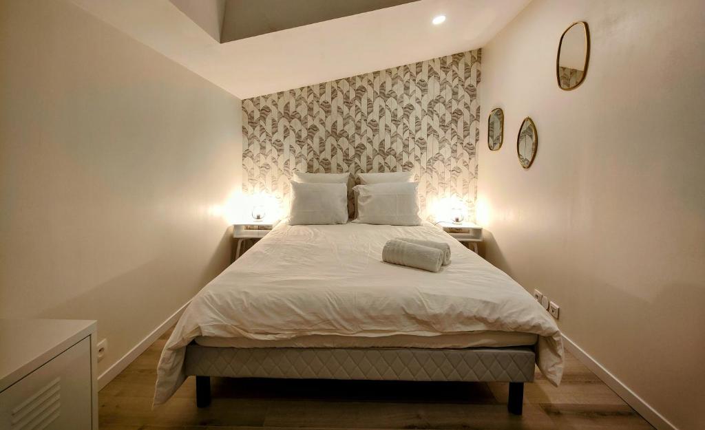 - une chambre avec un lit avec des draps blancs et 2 lampes dans l'établissement Le Bellerade - Rez-de-chaussée tout confort, à Dunkerque