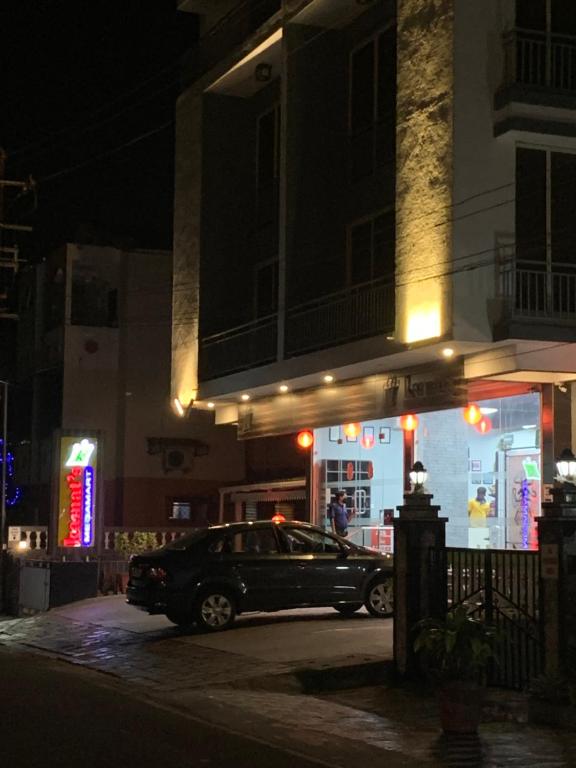 a car parked in front of a building at night at Kamat's Hilltop Leisure in Dona Paula