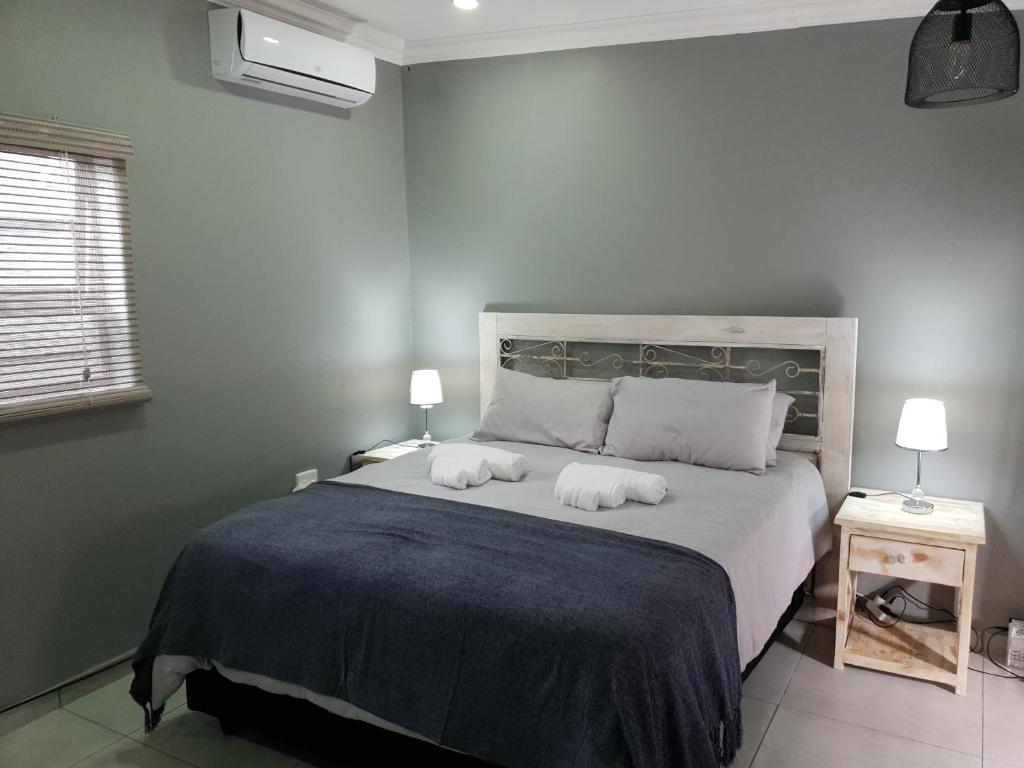 um quarto com uma cama grande com duas toalhas em Haleys Guest House em Benoni