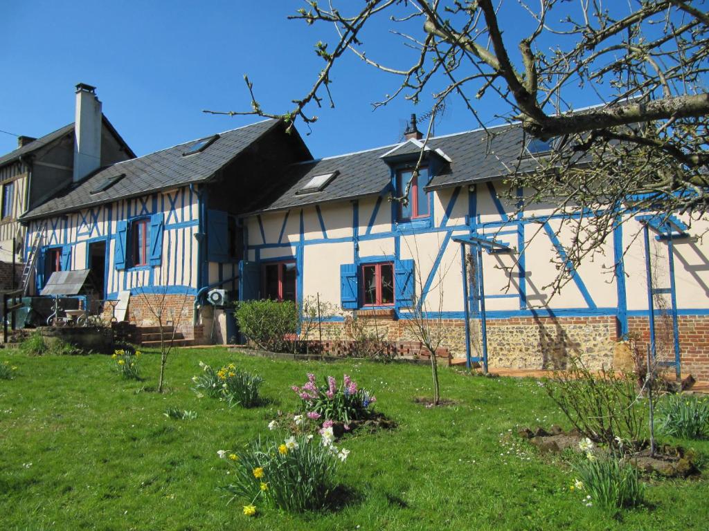 ein weißes und blaues Haus mit einem Hof in der Unterkunft La Roseraie du Prieure in Rosay-sur-Lieure