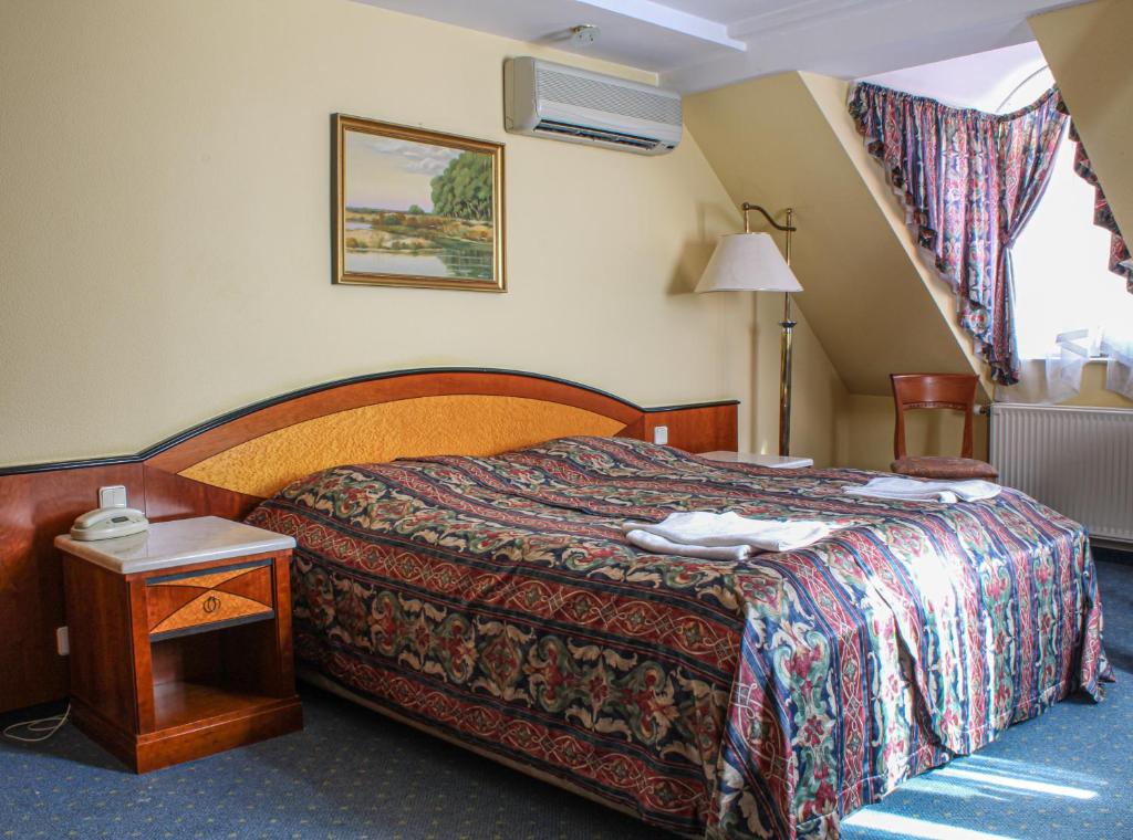pokój hotelowy z łóżkiem i stołem w obiekcie Offi Haz Hotel w Egerze