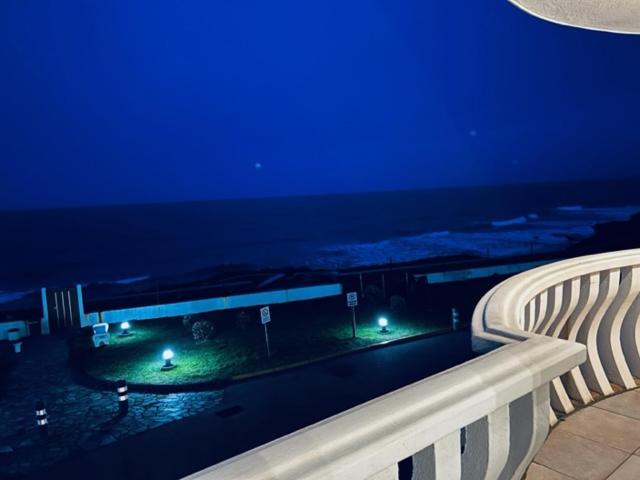 a view of the ocean from a balcony at night at Apartamento Oceano in Barreiros