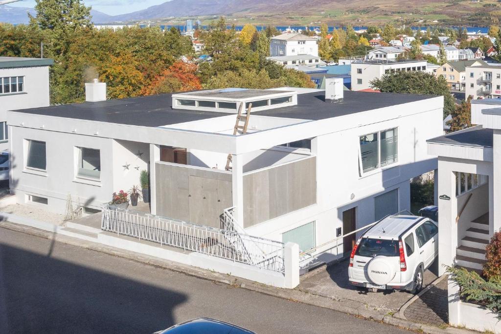 a white house with a van parked in front of it at Bjarmastígur 4 in Akureyri