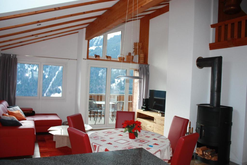a living room with a table and red chairs at Chalet Gerbera in Wengen