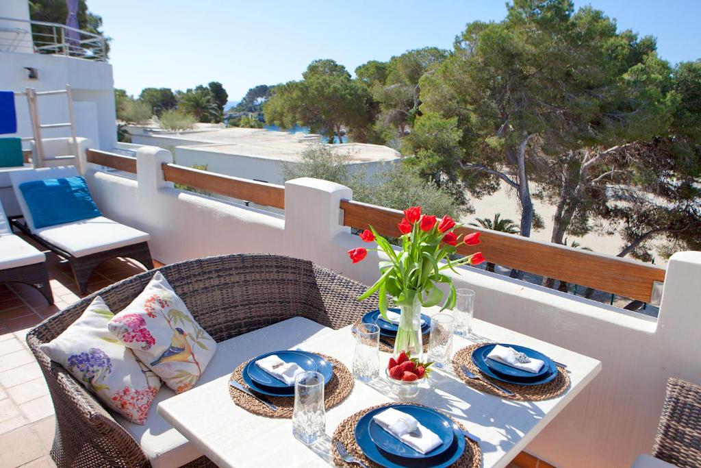 a table with a vase of flowers on a balcony at Bungalow Playa dOr 4 in Cala d´Or
