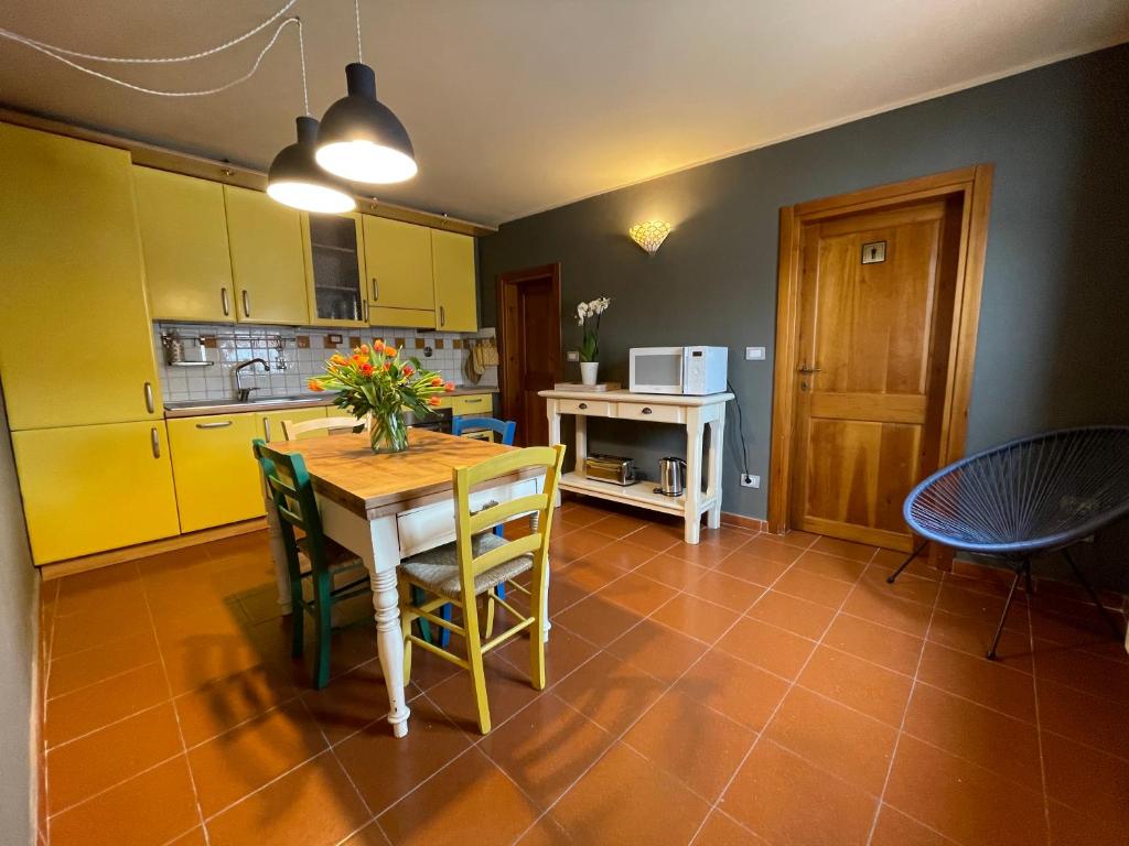 a kitchen with a table and chairs and yellow cabinets at Da Giulia in Florence