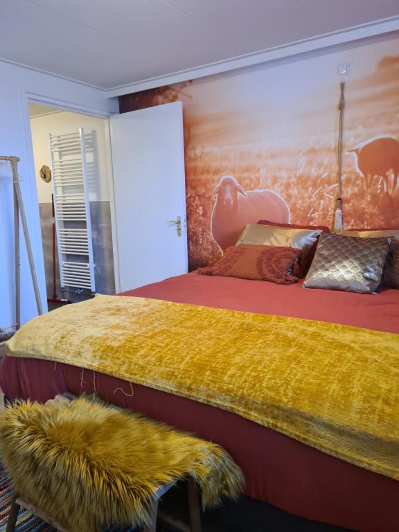 een slaapkamer met een groot bed met een gele deken bij Een Nije Dei in Arum
