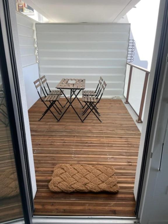 - une terrasse couverte avec une table, deux chaises et un tapis dans l'établissement Charming 45m in Aytré - near La Rochelle, à Aytré
