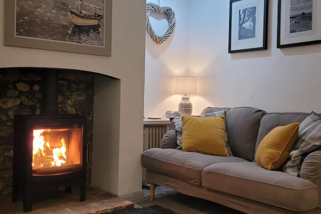 a living room with a couch and a fireplace at Fossil Cottage (Berryl Farm Cottages) in Whitwell