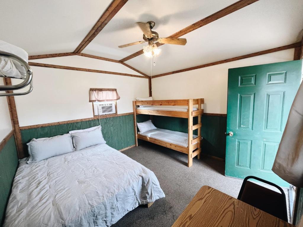 Mifflinburg的住宿－Cozy Cabin2 Within Campground，一间卧室设有一张床和一个绿门