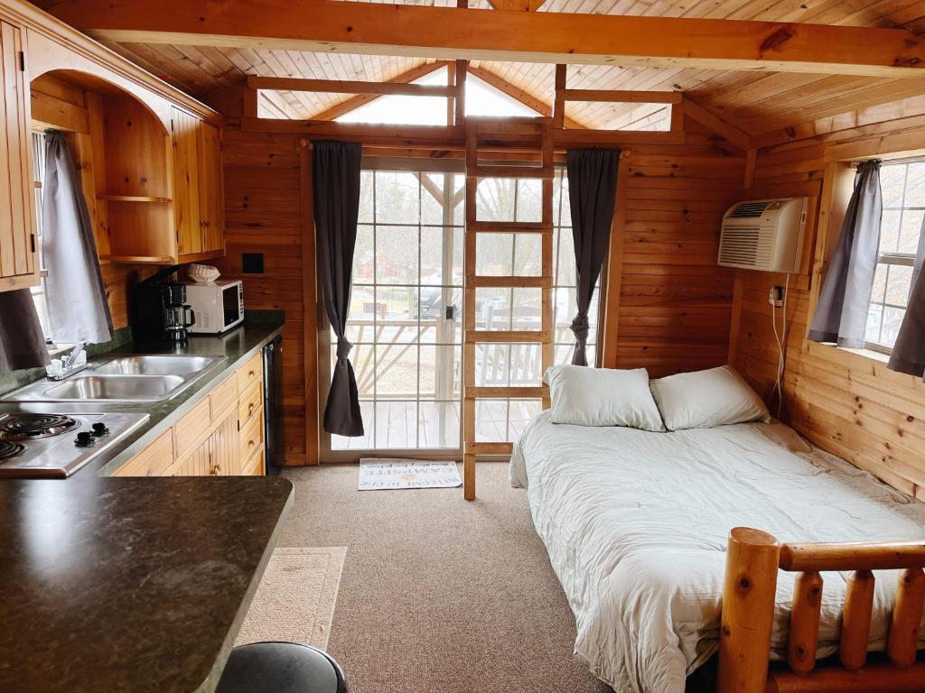 een slaapkamer met een groot bed in een houten huis bij Deluxe Cabin7 Within Campground in Mifflinburg