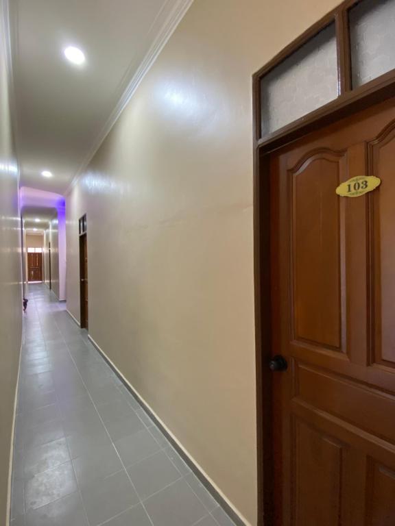 um corredor com uma porta com um sinal em Sasuka Guesthouse (Muslim Sahaja) em Marang