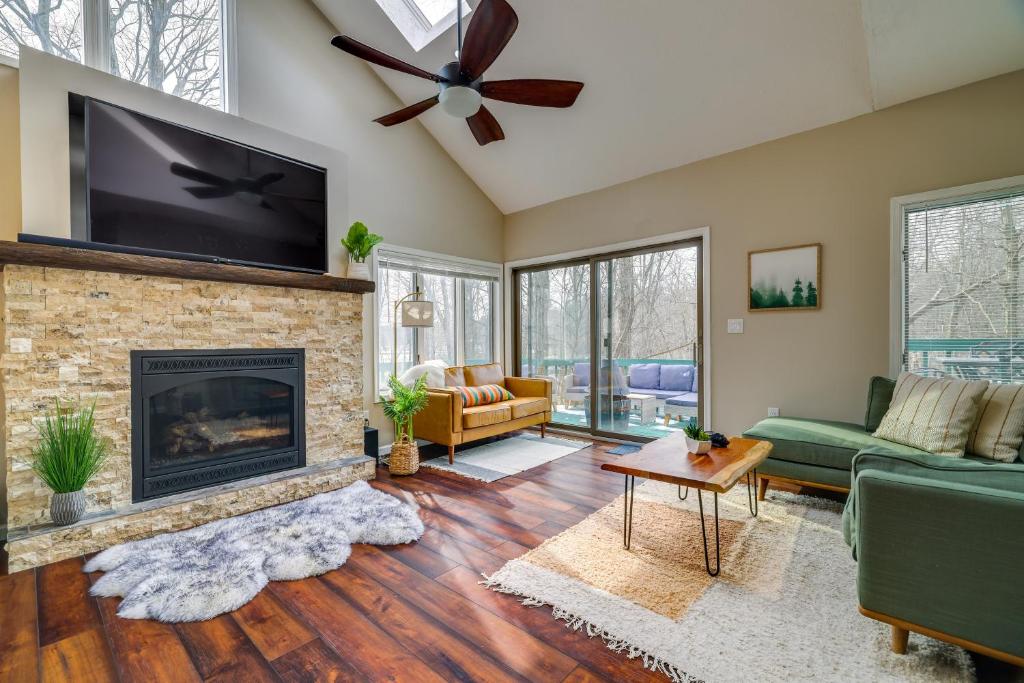 Una sala de estar con chimenea y TV de pantalla plana. en Lovely Poconos Cabin with Resort Amenities!, en Gouldsboro