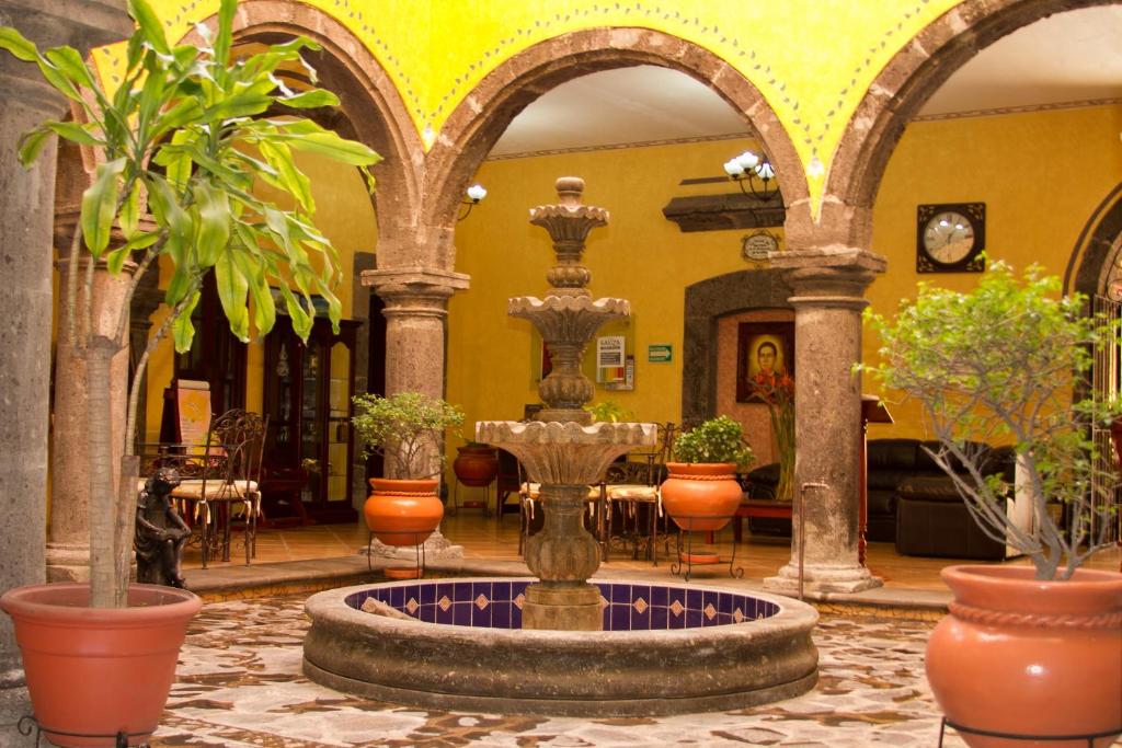 a courtyard with a fountain in a building with plants at Hotel Casa Dulce Maria in Tequila