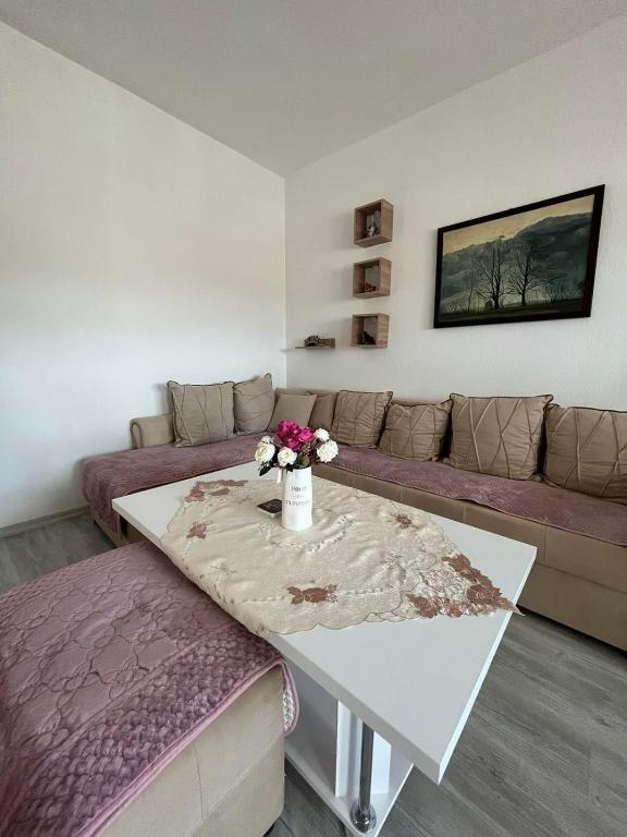 a living room with a couch and a table with flowers on it at Viktorija's Apartment in Gevgelija