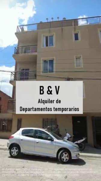 a white car parked in front of a building at B & V departamentos in San Salvador de Jujuy