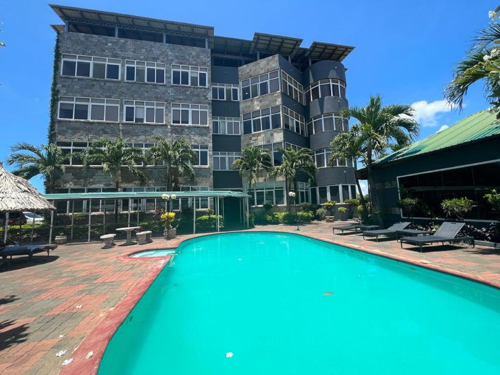 a swimming pool in front of a building at Colosseum Square Luxury Apartments in Dar es Salaam