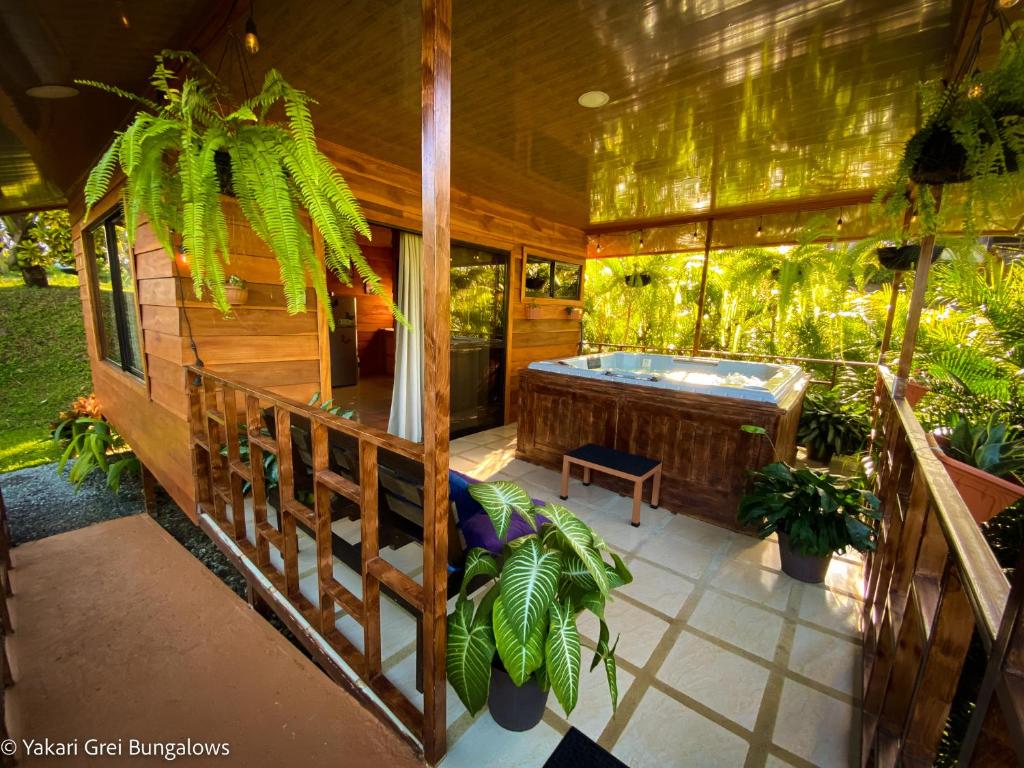 eine abgeschirmte Veranda mit einem Whirlpool auf einem Haus in der Unterkunft Bungalows Yakari Grei in San Ramón