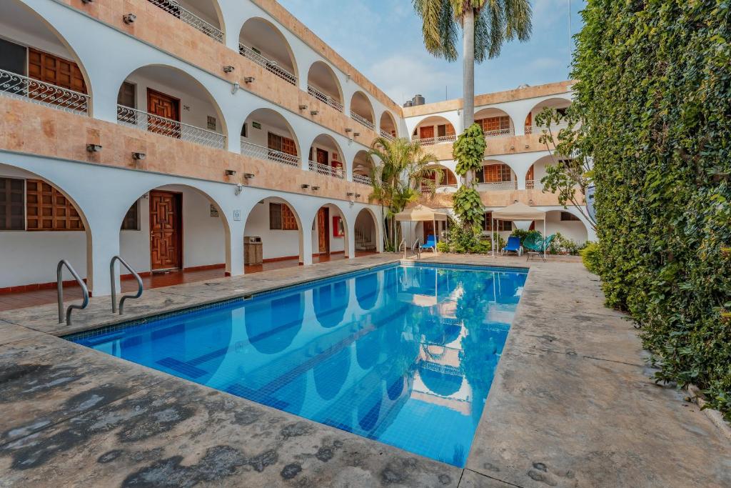 a swimming pool in the courtyard of a building at Hotel Maya Yucatan in Mérida