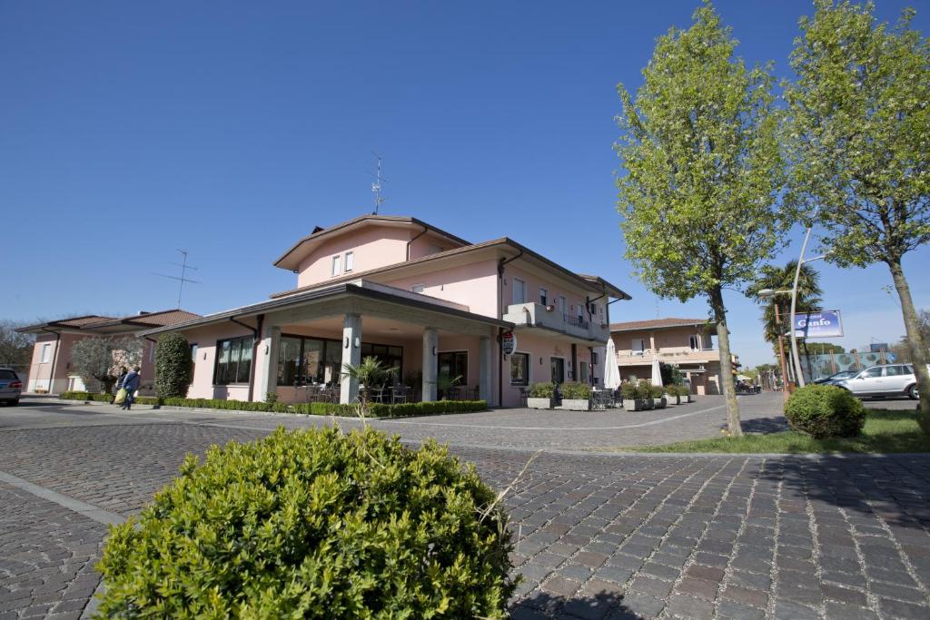 a building on a street with bushes in front of it at Hotel Ganfo in Sirmione