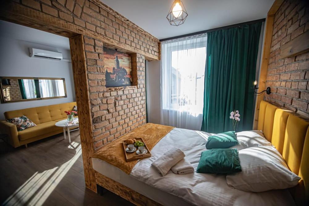 a bedroom with a bed and a brick wall at Czocha Studio Apartment in Leśna