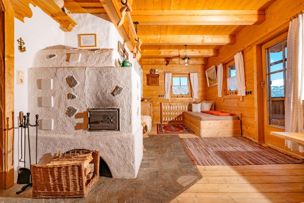 uma sala de estar com uma grande lareira num chalé de madeira em Magdalena Hütte em Hippach