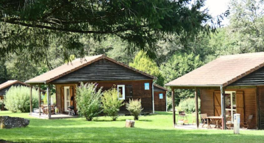 uma cabina de madeira com um pavilhão num quintal em Camping La Chapelle 