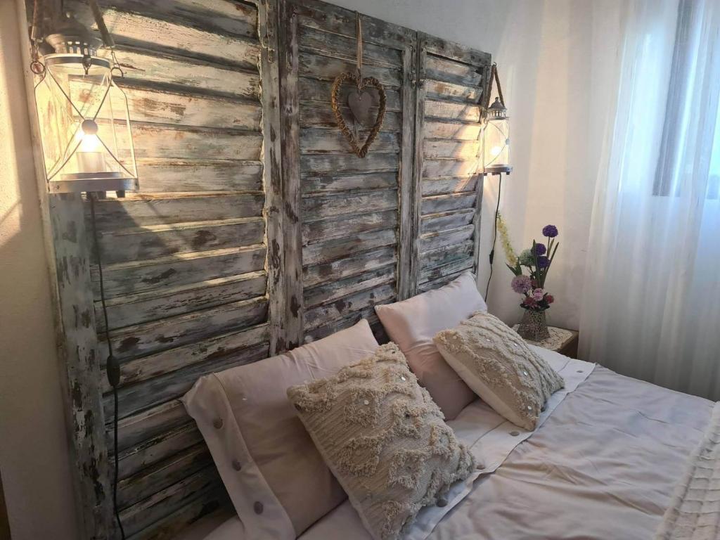 - une chambre dotée d'un mur en bois et d'un lit avec des oreillers dans l'établissement Apartments Klisić, à Bar