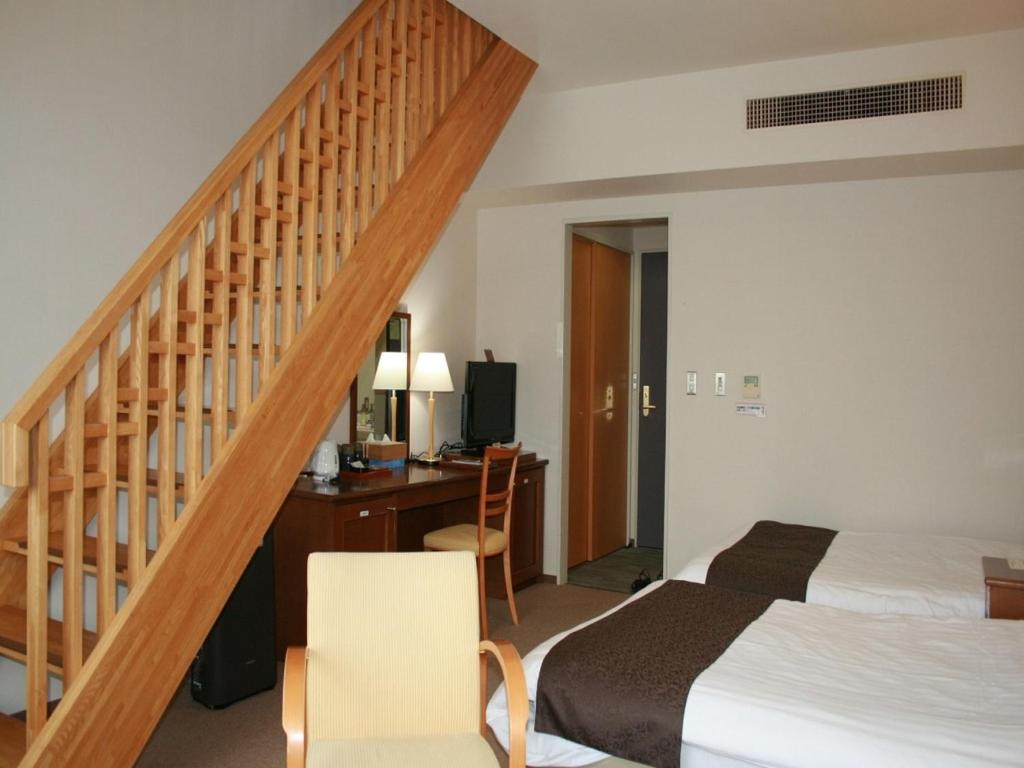 a bedroom with a bed and a desk and a staircase at Japanese Auberge Plaza Ryokufu Natural Hot Spring - Vacation STAY 03280v in Shimo-orube