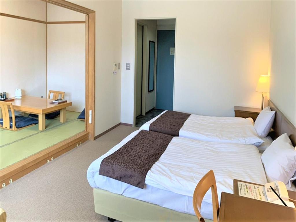 a bedroom with a large bed and a table at Japanese Auberge Plaza Ryokufu Natural Hot Spring - Vacation STAY 03205v in Shimo-orube