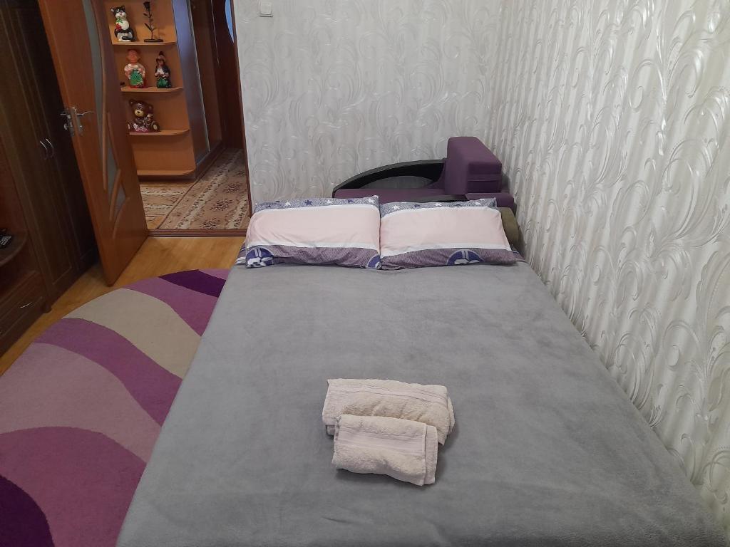 Апартаменти біля Автовокзалу في روفنو: سرير في غرفة عليها وسادتين