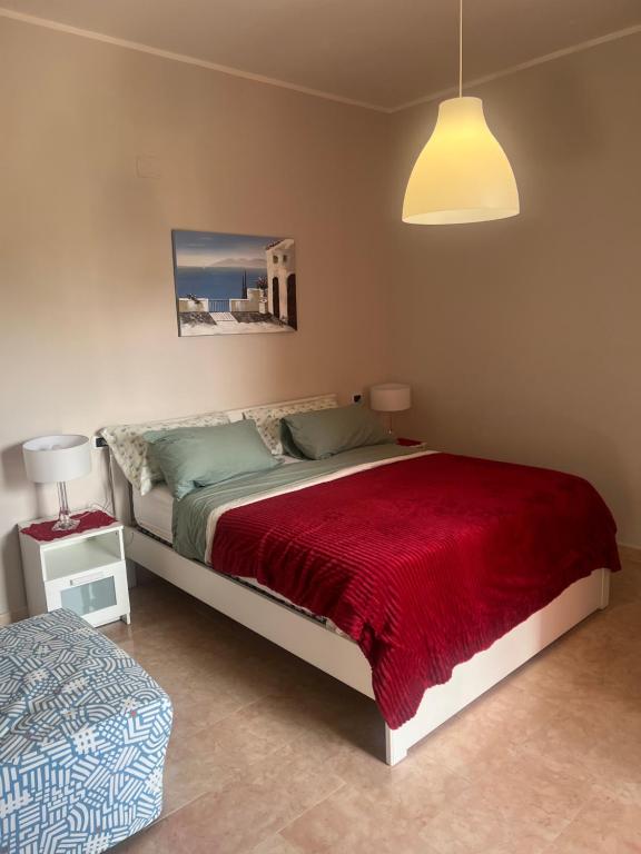 um quarto com uma cama grande e um cobertor vermelho em Esther Guest House em Castel Volturno