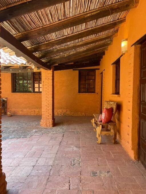 un patio con techo de madera y banco en Casa del Campo en Oaxaca de Juárez